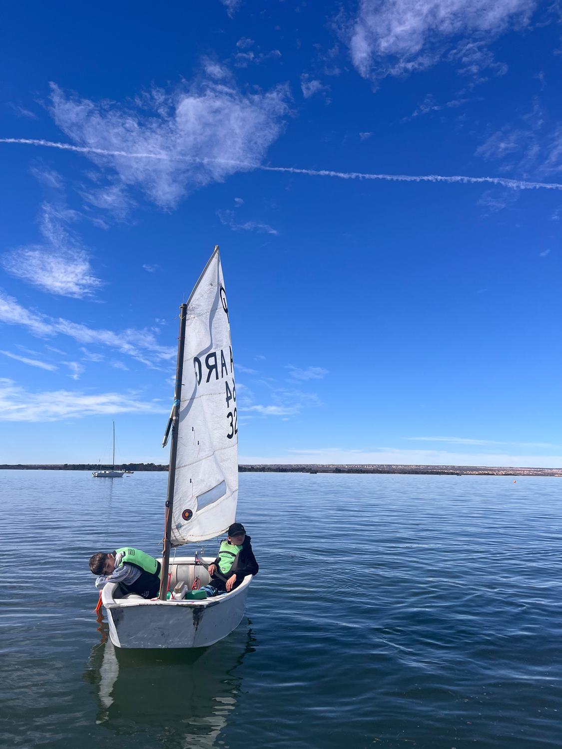 Dos chicos a bordo de un Optimist en el Dique Potrerillos